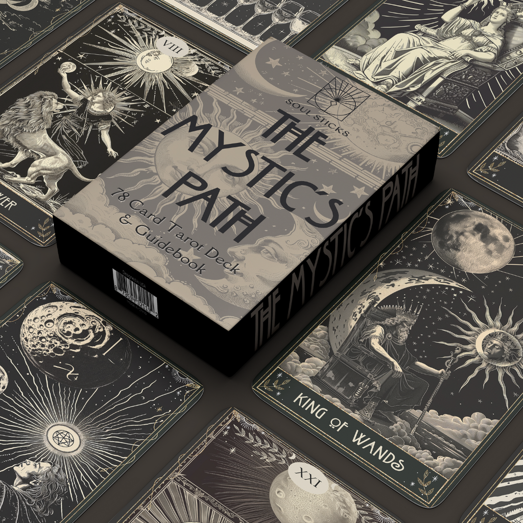 Box surrounded by cards:
“The Mystic’s Path tarot box surrounded by black and cream cards featuring moons, suns, and stars.”
