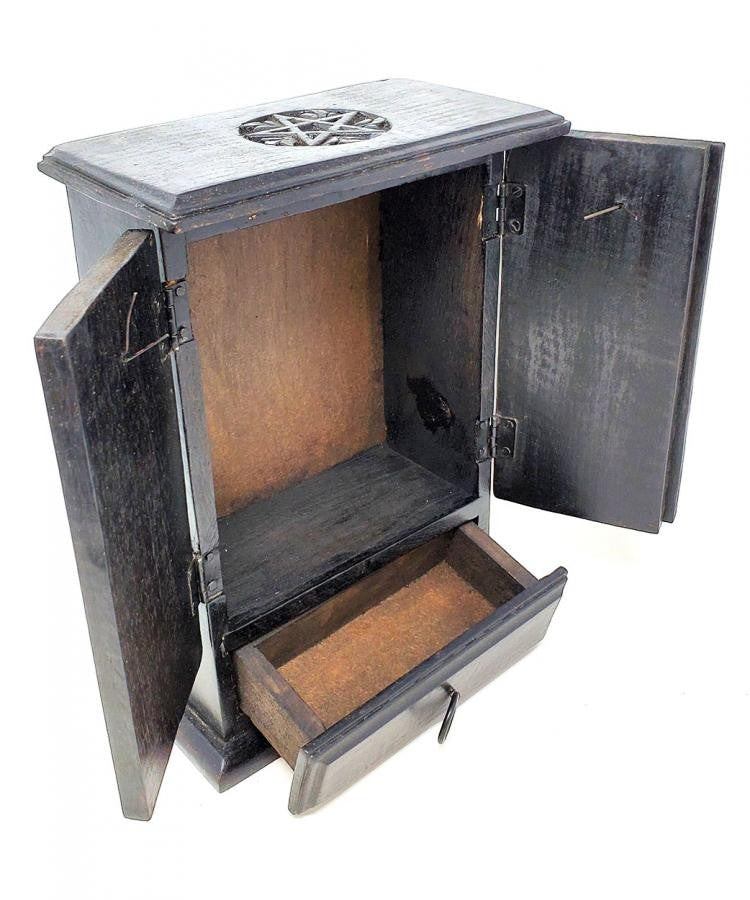 Crystal Fairy Patch matte black wooden cupboard with carved pentagram motifs, hinged doors, and a pull-out drawer for ritual tools.