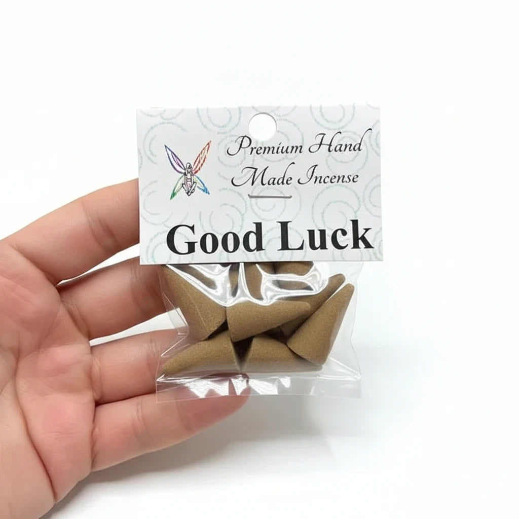 Crystal Fairy Patch Good Luck premium hand made incense cones in a clear plastic bag held in a hand against a white background.