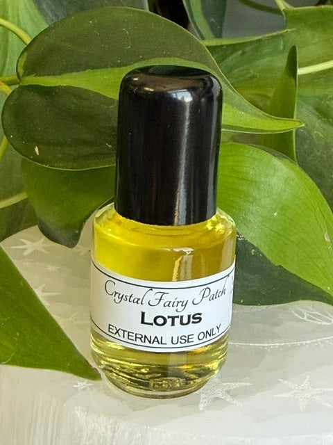 Crystal Fairy Patch relaxing and cooling Lotus oil in a small glass bottle with a black cap, set against green leaves.